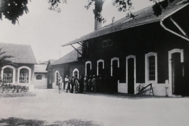 Photographie d'époque de l'usine Bugatti de Molsheim dans les années 1930 : long bâtiment à grandes baies cintrées.