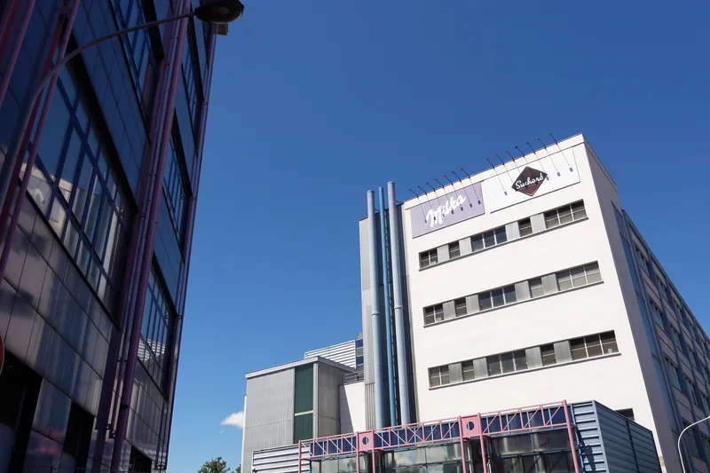 Bâtiment blanc de l'usine Suchard à la Meinau, à Strasbourg, avec des gaines métalliques sur la façade, en 2014.