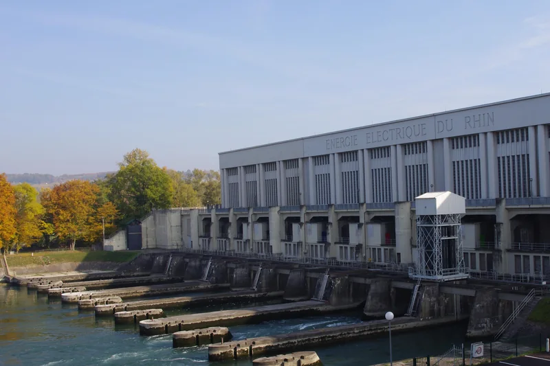 La centrale hydroélectrique de Kembs, avec l'inscription Énergie électrique du Rhin en façade, derrière les vannes du barrage.