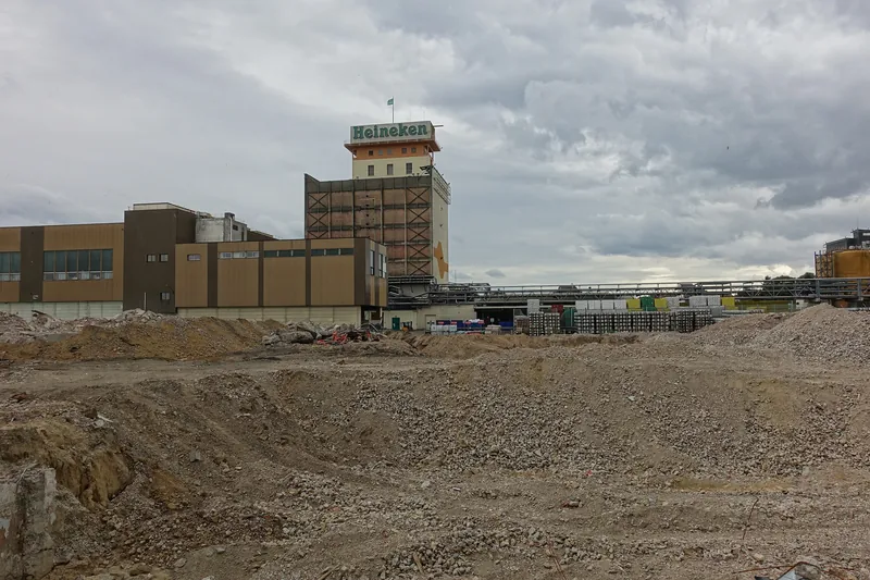 La tour de l'usine Heineken de Schiltigheim derrière un terrain de gravats, là où des bâtiments ont été démolis, en 2018.