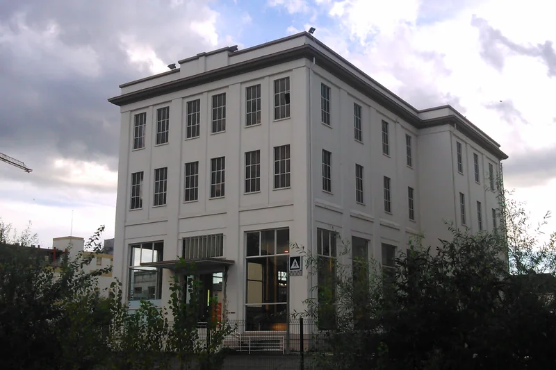 L'ancienne brasserie Kronenbourg K1 à Cronenbourg, à Strasbourg : bâtiment blanc à étages sous un ciel nuageux, en 2014.