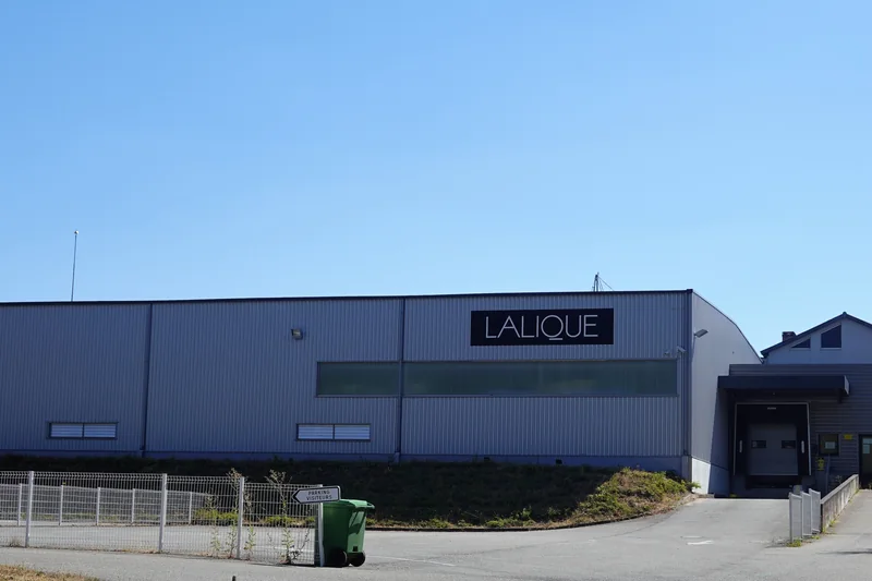 Le bâtiment bleu de l'usine Lalique à Wingen-sur-Moder, avec le nom de la marque en lettres blanches sur la façade, en 2022.
