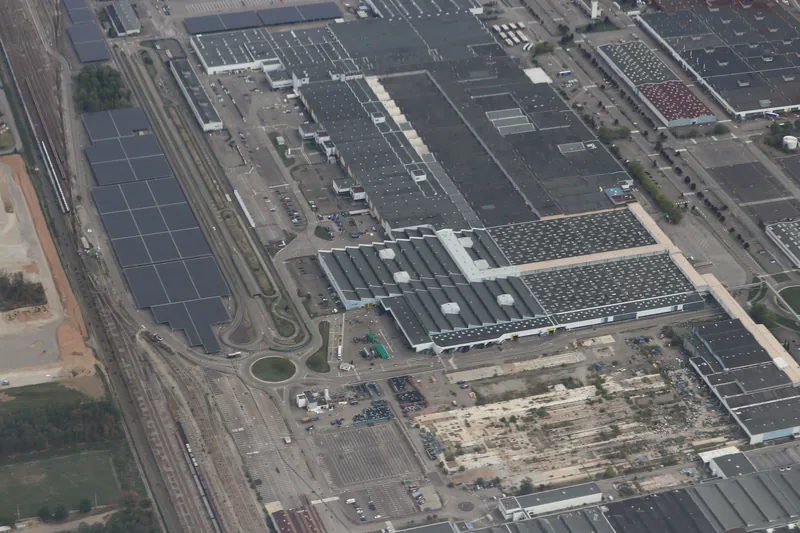 Vue aérienne rapprochée des grands halls, des voies ferrées et des parkings de l'usine Stellantis de Mulhouse, en 2026.